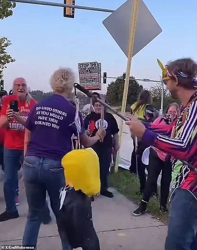 Protester wearing "Make America Kind Again" shirt smashes piñata of president